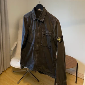 Stone Island overshirt  - En Stone Island overshirt i storlek small. Denna modell är något mer ovanlig än de andra då den har dubbla bröstfickor. Den är svart i färgen. Säljs pga att den tyvärr inte används. I övrigt är denna overshirt i väldigt bra skick och den är väl omhändertagen!