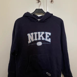Nike hoodie - Vintage liknande Nike hoodie i storlek M, men skulle säga att de är en S.Färgen är marinblå med vitt tryck på! Säljer för jag ej använder längre!☺️ 450kr eller bud🥰