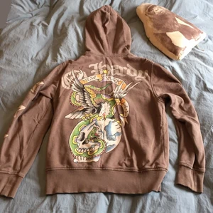 Snyggaste ed Hardy tröjan  - Den perfekta ed Hardy tröjan i en fin brun färg, är köpt på humana för drygt ett år sedan och har endast använts två gånger. Har jätte många coola detaljer!! 