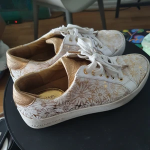 Michael Kors sneakers - Vita/guldiga sneakers från Michael Kors i storlek 37,5. De är använda men fortfarande i bra skick. Nypris runt 2000 kr.