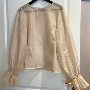Beige/rose mesh blus  - Beige/rosé lite genomskinlig blus med volang i ärmen! Fint med en brallet under! Köpt från Gina Tricot i storlek 40 så den är lite ”fluffig” på mig (M) och sitter alltså inte tajt! 🚚Köparen står för frakt 🚚 