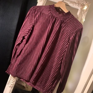 Topp i lila sammet - Så skön och fin topp med halvpolo. 🥰 Randig sammet. Färgen är svår att fånga på bild, men härlig djupt lila. Lappen borta men rätt säker på att storleken är L (sitter som en lite större M) 💕