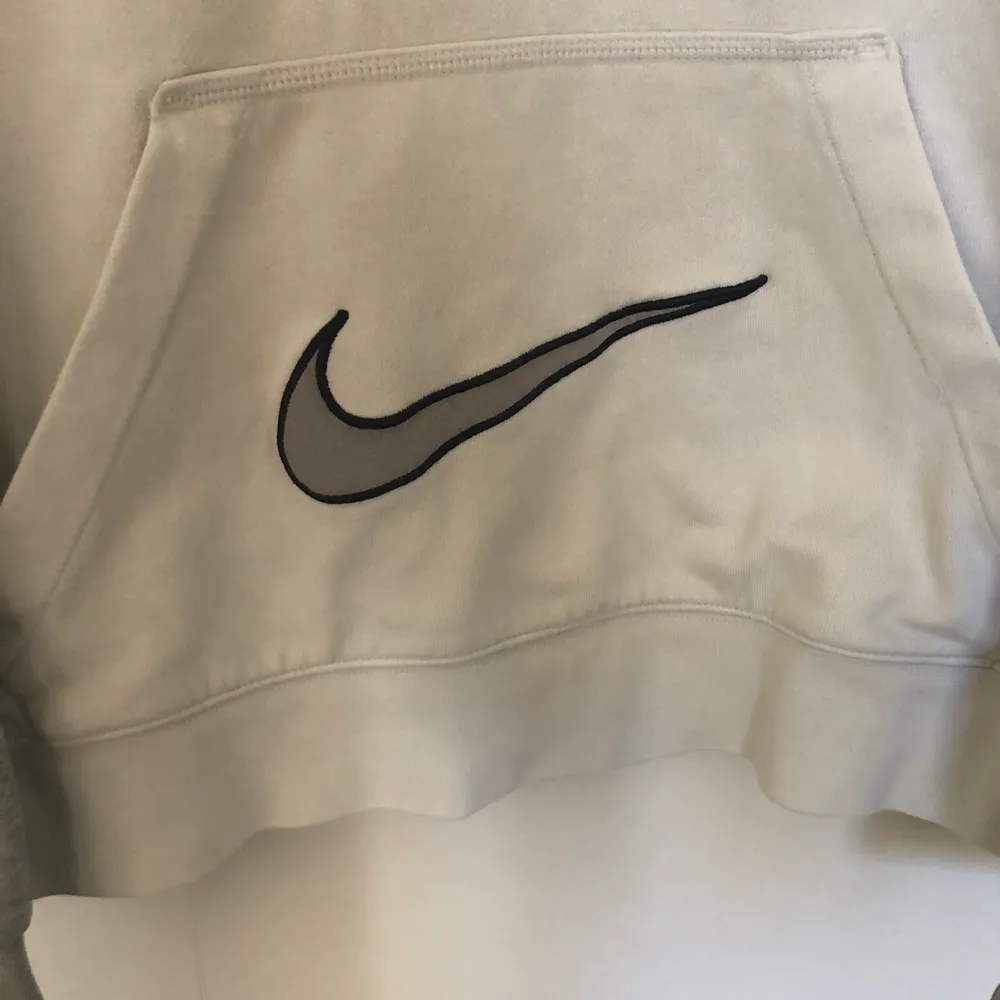 Vintage nike hoodie grå och vit färg med en stor swoosh på fickan. Den är i bra skick och har lite spår på nopper. Tröjan passar som en Medium och har boxy passform.. Hoodies.
