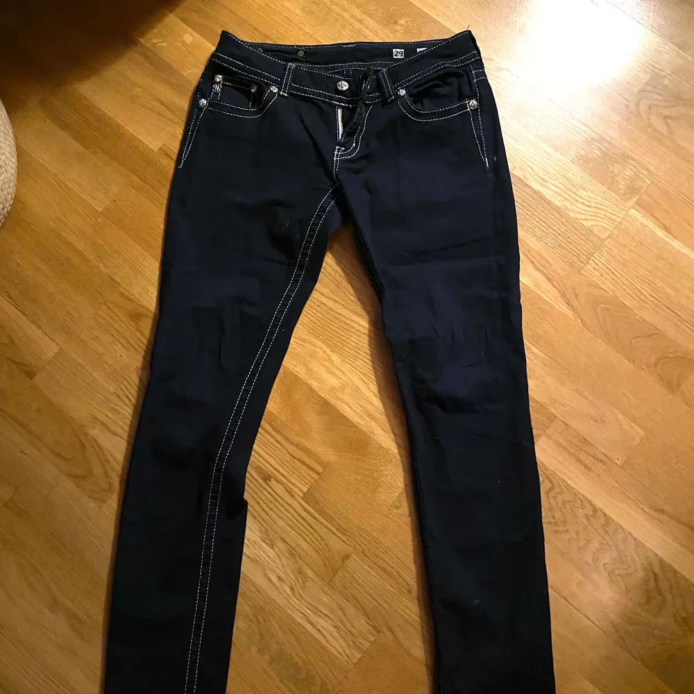 Svarta as coola jeans med vita sömmar. Fickor med änglavingar på. Använda ca 3 gånger. Low waisted! Storlek 28. Jeans & Byxor.