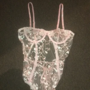 rosa blommig spetsbody - rosa spetsbody med blommigt mönster. köpt på shein, huuur fin som helst men är tyvärr för liten för mina bröst💔 (har C/D kupa) köparen står för frakt, pris kan diskuteras