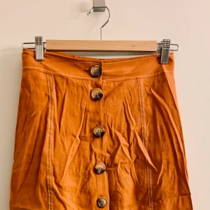 Superdry midi kjol - Kjol från Superdry använd sparsamt i somras i en fantastiskt rost/orange nyans, st 36/S men passar både XS och M beroende på hur man vill ha den. I midjan eller på höften🎀