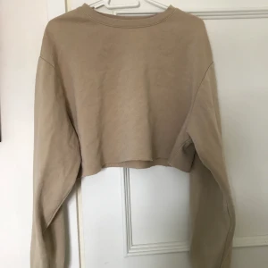 Cropped beige tröja - En croped beige sweatshirt som är från hm.