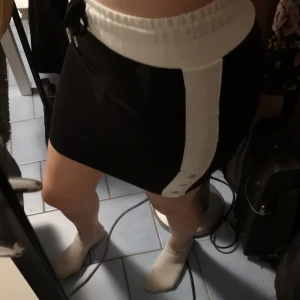 Mjukiskjol, New Yorker, strl S - Svartvit kjol med dekorationsknappar och justerbara snören från New Yorker. Använder inte. 