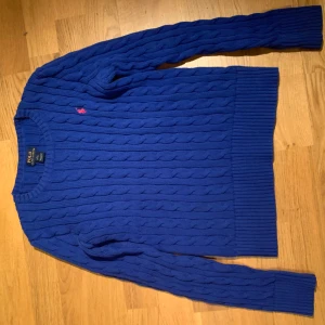 Kabelstickad Ralph Lauren tröja, barn - Kabelstickad Ralph Lauren tröja i barnstorleken 12-14 år (L). Tröjan är i väldigt bra skick