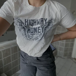 Vit T-shirt med motiv - Tryckt design. Flowy (tunt & luftigt) tyg. Svart tryck. Rund krage. Kort ärm. Används ett ytterst fåtal tillfällen, så mer eller mindre nyskick! Mottagare står för frakten (vid köp av fler plagg, kan fraktkostnaden minska!)