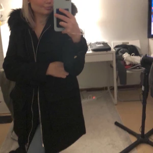 Svart kappa med luva  - Svart kappa med fake päls på luvan med 2 stora fickor. Jag är 1,62 cm och kappan går ner till mina knän ungefär. Frakten ingår i priset💞💞