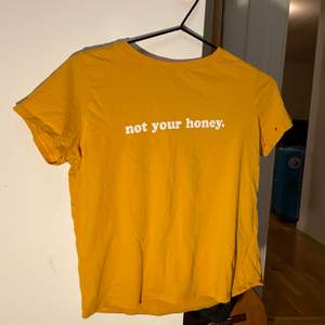 Sjukt snygg senapsgul tshirt från Gina tricot i storlek XS. Det står ”Not your honey” på den. Den har några små hål, men de märks inte när man har på den:) Pris kan diskuteras. Frakt betalas av köpare.