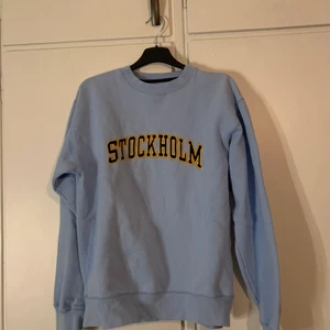 sweatshirt  - en Ljusblå sweatshirt i st S med texten Stockholm skrivet på bröstet  i bra sick men lite nopprig☺️
