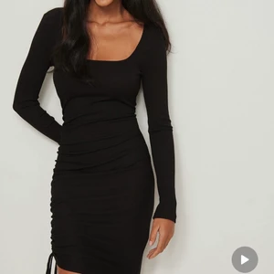 Svart klänning i storlek L  - Klänning med dragsko och ryschdetalj från NA-KD. Endast använd en gång. Storlek L! 