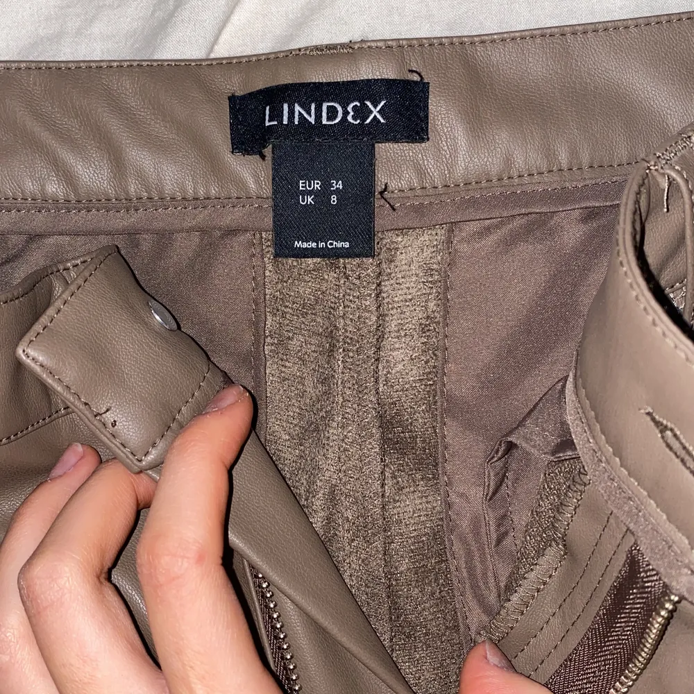 Bruna skinnbyxor från Lindex med fram slits på benen. Aldrig andvända.. Jeans & Byxor.