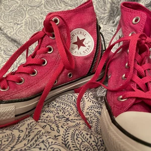 Höga converse  -  Jätte coola och snygga höga converse skor som köptes för några år sedan. Säljs förmodligen inte längre. Dom är rosa och grå, i bra skick, och bak är det ”dragkedjs detaljer”. Säljer då skorna inte passar längre :( Går att diskutera priset privat! Storlek 37! DM om du är intresserad! ⚡️⚡️⚡️