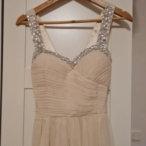 Balklänning - Nästan oanvänt, elastiskt i överkroppen, ingen dragkedja, sitter väldigt fint, lång underdel, färgen är ljus beige med en hint av orange rosa