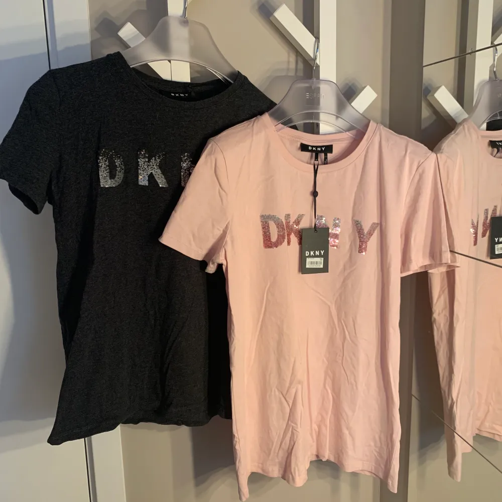 Säljer två oanvända DKNY T-Shirts i stl S men passar XS-M. Inköpta för 39,90$ styck och säljs nu för 150kr styck eller 200kr för båda. Som sagt jättefina T-Shirts i nyskick. En prislapp finns kvar. Kan självklart stryka tröjorna innan dem överlämnas. . Toppar.