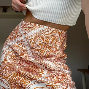 Mönstrad kjol från Gina Tricot - Kjolen kommer från Gina och är knappast använd. Plagget är i gott skick och är i satin material.