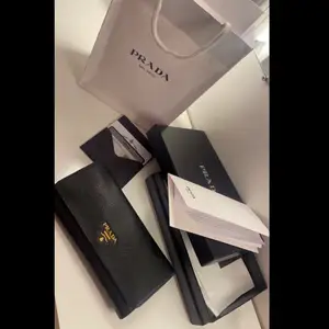 Säljer nu min  ”Prada Saffiano Large Leather Wallet” som är alltså den stora modellen. Jag har mest haft den liggandes hemma så den är i nästintill nyskick. Allting följer med, såsom påse, kvitto, certifikat / äkthetsbevis, låda, mm…. Även korthållaren medföljer, som går att sätta fast i plånboken eller tas av och användas separat. Plånboken är köpt för 7200 kr och säljes för 4000kr. Pris kan diskuteras vid snabb affär. 