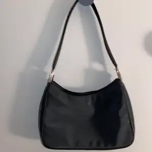 Fin svart axel väska med silver detaljer . Köpt på secondhand och ser använd men finns inte några särskilda märken. 