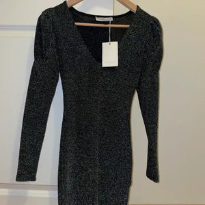Glittrig klänning - En glittrig klänning med lite puffiga armar från pull & bear i st XS. Passar perfekt för nypr eller andra festligheter. Endast provad (har fortfarande prislappen). 
