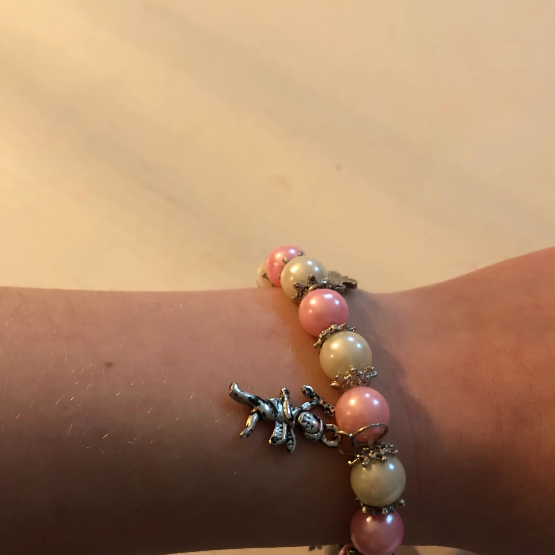 Rosa/vitt armband med små figurer