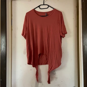 T-shirt med knyt - Korall/Rostfärgad t-shirt (lite ljusare än på bild) i skönt tyg, har knyt nedtill men jag fattar inte hur en gör det bra lol. Köpt sommaren 2021, använd 2ggr. 💌Frakten är baserad på frimärken. Önskas postnords egna paket löser vi det. 🎈