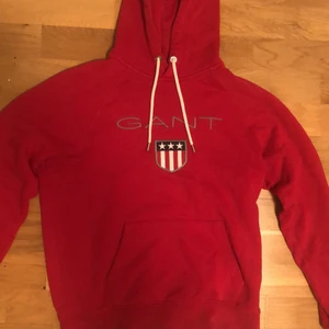 Gant hoodie  - En röd Gant hoodie i bra skick, riktigt skön och mysig. Den har länge varit för liten för mig nu och har bara hängt i garderoben. Köptes för 1100kr men säljs för 300kr.
