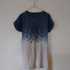 T-shirt med tryck av Hamsahand samt stjärntecken m.m. som en oversize S eller vanlig M. Fint skick.