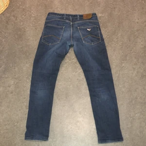 Aramani jeans - Liten skada på den bruna grejen där bak, Men det märkt inte med bälte på. Annars är jeansen i bra skick och köpta i Nk för ungefär 1600. Dom är storlek 31/34