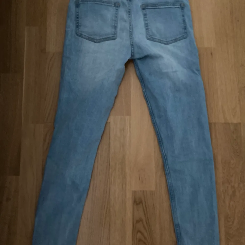 Blåa jeans i bra skick. Jeansen är i stretchigt material och har hål på båda knäna. . Jeans & Byxor.