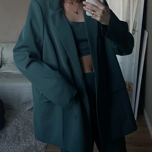 Mörkgrönt set /kostym från missguided - Mörkgrönt set från Missguided innehållande Kostymbyxor, kort topp & kavaj. Oversize look. Snyggt & bekvämt. Storlek XS