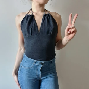 Svart halterneck topp med knytband - Denna svarta toppen bar min mamma när hon var ung! Skön, luftig, halterneck topp med justerbar snörning. Perfekt ovanpå bikinin eller bara snygg och skön att ha utan behå under. Har en likadan i vit.