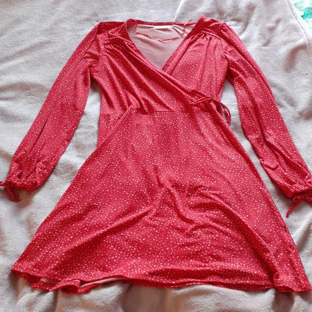 En röd klänning med rosa prickar från gekås/ullared i strl M. Den köptes för att användas i julas och har sedan dess bara blivit liggandes. Det är band på armarna så att du kan spänna dom efter din handled samt ett litet vid midjan. Klänningar.