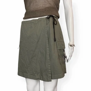 Cargokjol  - Camouflage grön cargoshorts på baksidan och knyt kjol på framsidan. Från Birabira, storlek L. Ingen materiallapp finns.Mått: Midjebredd 40cm, längd 40cm. Spårbar fri frakt.  