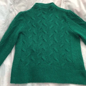 Grön stickad tröja  - Säljer denna gröna stickade tröjan efter 2 lojala år. Har använt den mycket vilket har satt sina spår på tröjan, men utöver det är den fortfarande lika varm och skön som när jag köpte den. Den är i storlek L men är relativt liten i storleken då den passar mig som egentligen bär storlek S.