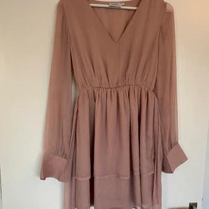 NA-KD Klänning 34 - En fin gammelrosa klänning från Maria Paolas kollektion för NAKD. Storlek 34, knappar på armarna och midjeband. Endast använd 1 gång! Nypris 599kr.