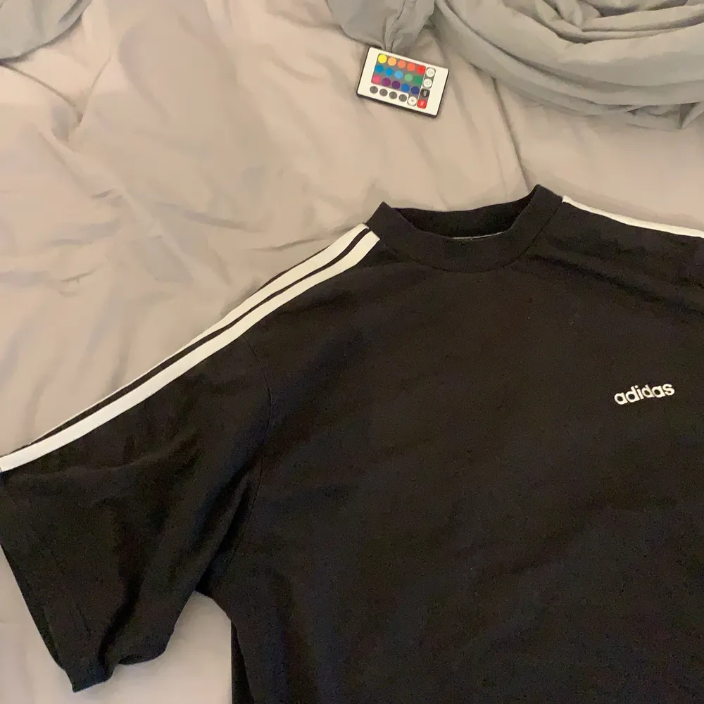 svart baggy adidas t shirt me vita sträck längs axlarna typ, bra skick, tror frakt blir 45. T-shirts.