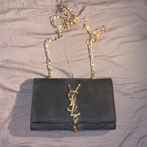 Väska  - Fake SAINT LAURENT väska. Aldrig använd, men har legat hemma i en garderob i ett par år. Fint skick. Kan skicka fler bilder om så önskas, ställ gärna frågor.