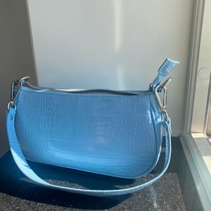 Rosemunde väska  - En oanvänd väska från Barbara Kristoffersens egna märke. Är i väldigt bra skick då den aldrig är använd. Du får även med ett längre band till väskan. 