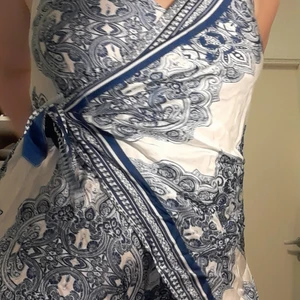 Byxdress i snyggt mönster - Oanvänd Jumpsuit i shorts modell. Snyggt mönster med fin knytdetalj i midjan som du kan knyta hur du vill. Storlek 38.