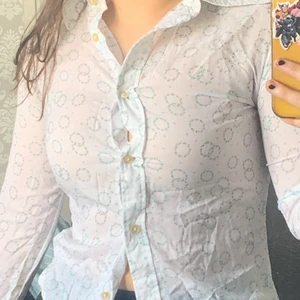 Vit skjorta med blå små blommor och gröna löv.  - Helt ny!!! säljs på grund av att den är för liten, står att det är storlek 38, känns dock som en S. Den är köpt på secondhand och är endast använd en gång. Sitter super fint! 