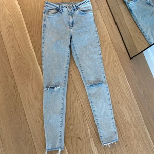 Ljusa jeans BIKBOK XS - Jeans med hål i knäna och slitningar längst ned. Från Bikbok - modell JP Higher, storlek XS. Jag är 159cm lång och byxorna slutar vid mina anklar. Frakt tillkommer