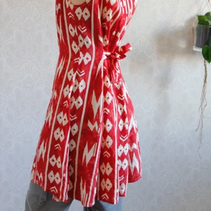 Färgstark figursydd klänning - En röd mönstrad klänning. Figursydd så det ger kurvigt intryck. 