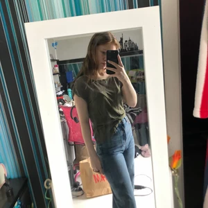 Grön T-shirt  - Grön T-shirt från H&M storlek XS, Har två små hål ett under sömnen längst ner och ett anat ett par centimeter ifrån på magen, märks knappt. Väldigt fin men används inte längre