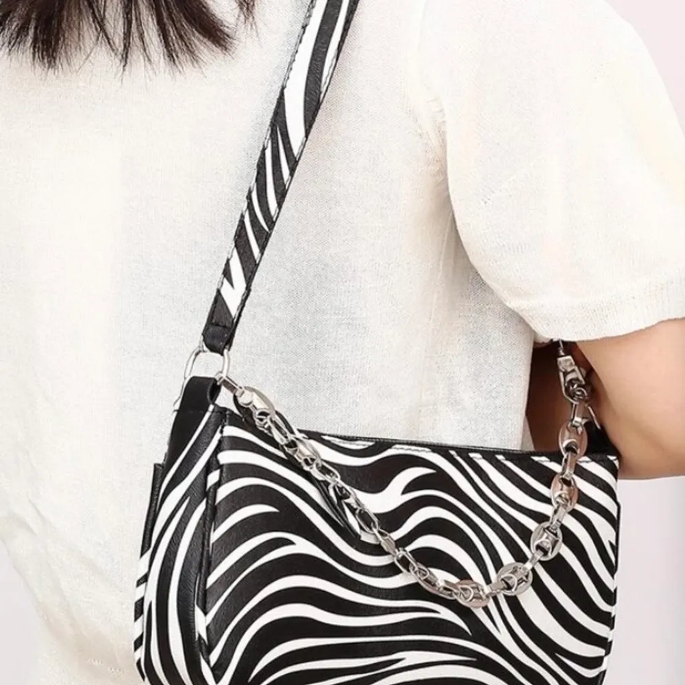 Säljer denna zebra väska fast utan kedja. Mycket fint skick. Säljer för 100 kr + frakt. Väskor.