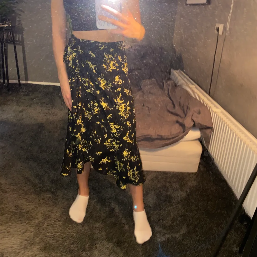 En svart kjol med gula blommor från Gina Tricot i storlek 34. Den är inte använd speciellt mycket och därmed i bra skick. . Kjolar.