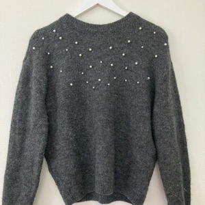 Stickad tröja  - En grå stickad tröga från H&M med vita pärlor upp till halsen