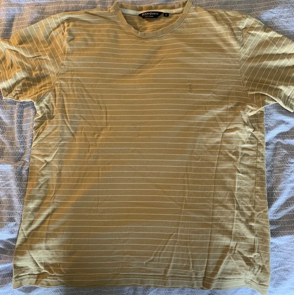 Gul/Beige randig Yves Saint Laurent Tshirt med liten logga på bröstet i bra skick Stl M . T-shirts.